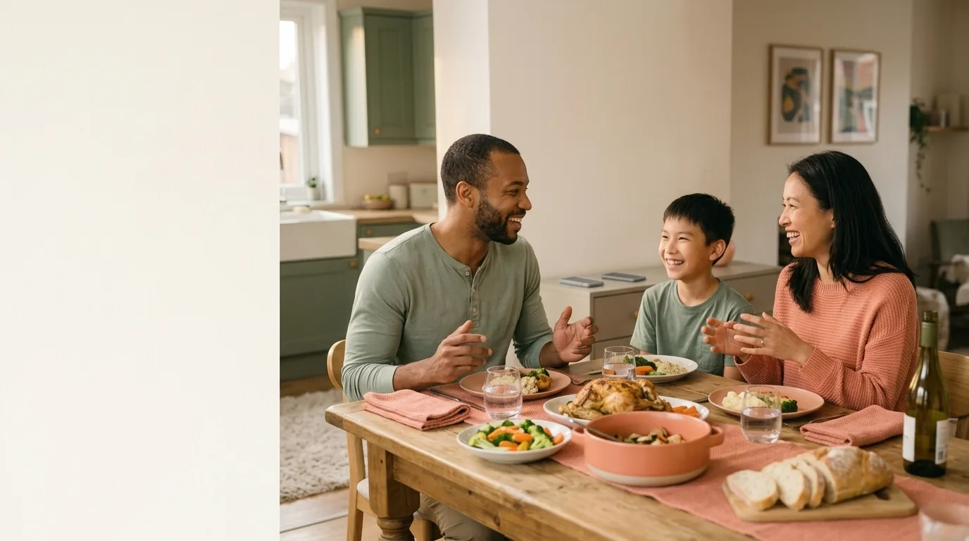 A blended family laughing together over a relaxed dinner at home
